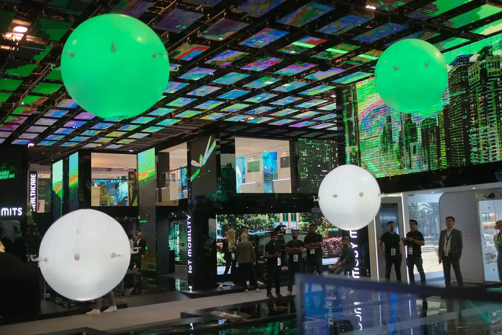 Glowing green and white orbs floating through the Etisalat event space in Dubai