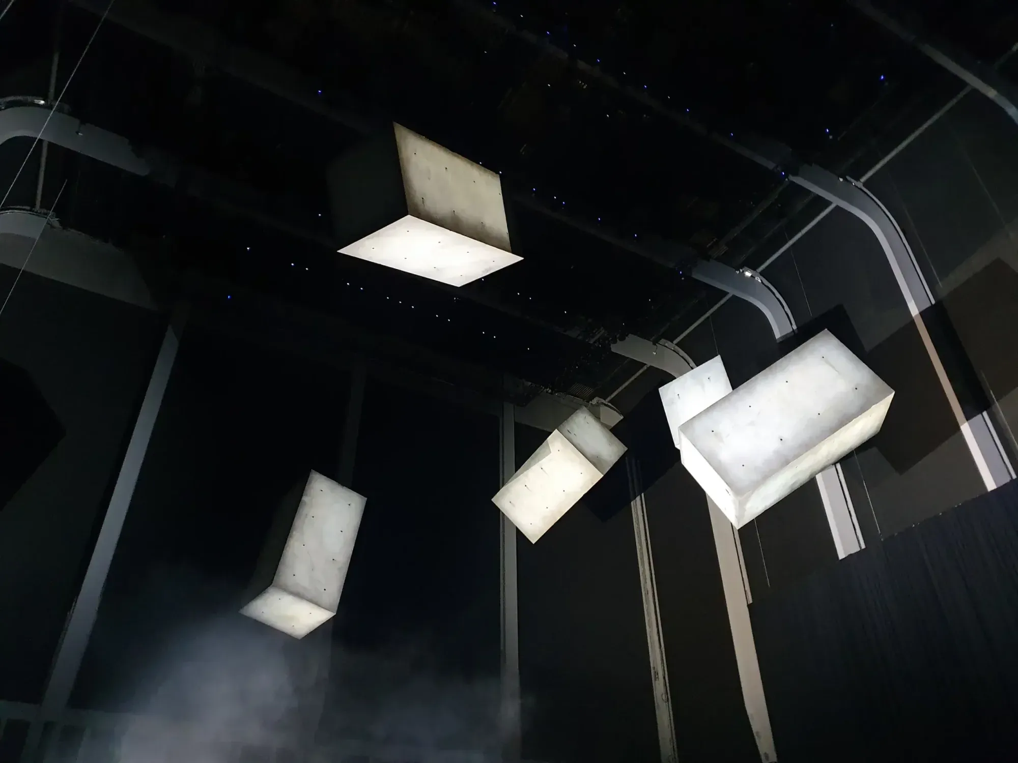 Five floating concrete monoliths lit against darkness in the Drifter installation
