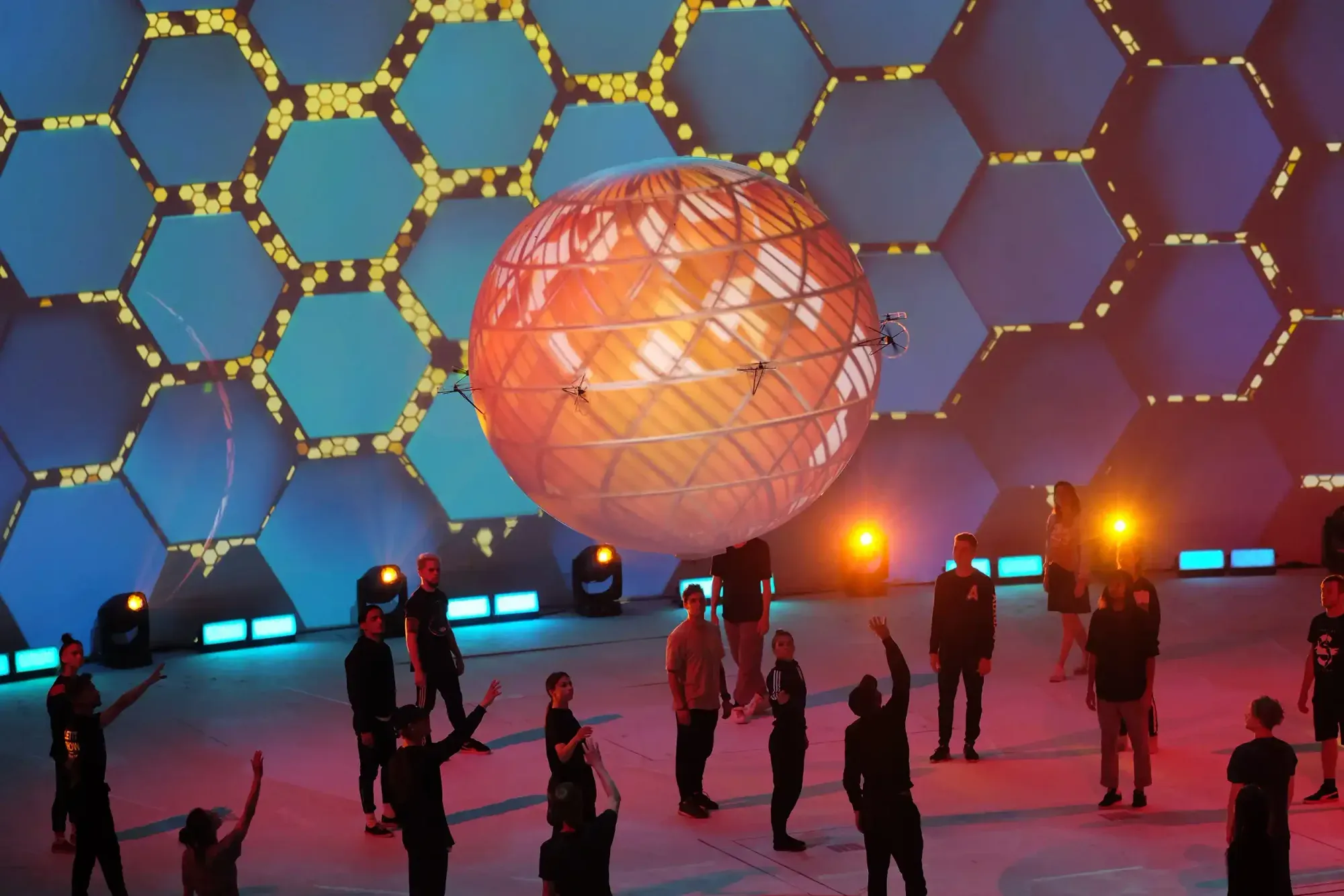 A glowing orange planet orb hovering above performers at the Expo 2017 opening ceremony