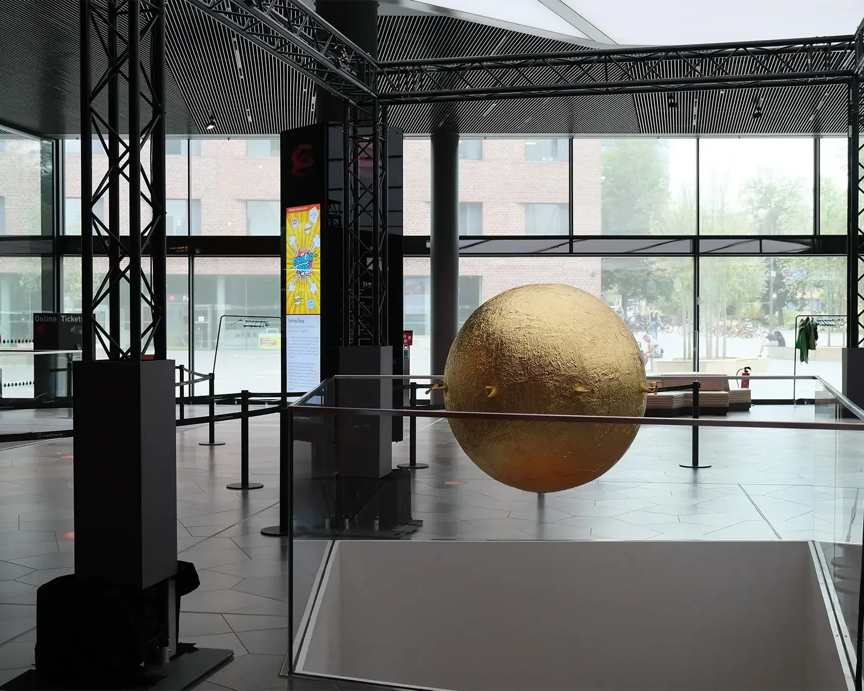 A golden sphere installation being prepared in the AI Blossom exhibition hall